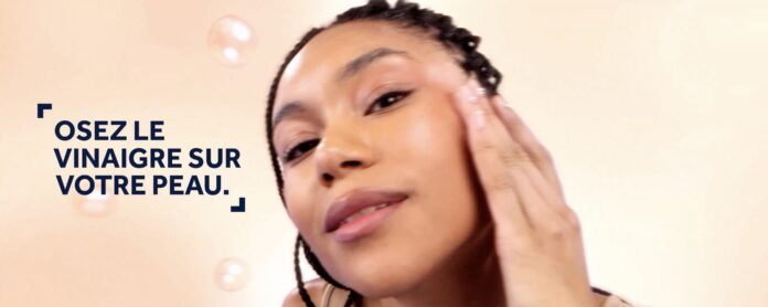 site-industries-cosmetiques A woman with braided hair touches her face and looks at the camera. Next to her, a text in French reads: 