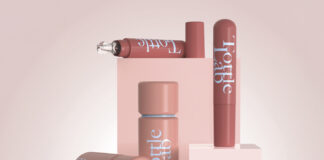 site-industries-cosmetiques 四个印有 "Fottle Lab "字样的粉红色化妆品瓶摆放在白色的平台上和周围。其中一个瓶子带有滴管，其他瓶子均为圆柱形，表面光滑闪亮。.