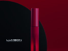 site-industries-cosmetiques Dois elegantes tubos de rímel vermelho com as palavras "MY MUST" são apresentados num fundo vermelho escuro e preto. Um tubo está na vertical, enquanto o outro está na horizontal. O logótipo Lumson aparece à esquerda.