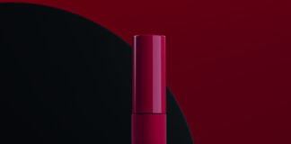 site-industries-cosmetiques 在深红和黑色的背景上，两支优雅的红色睫毛膏管上印有 "MY MUST "字样。一支直立，另一支横放。朗臣的标识出现在左侧。.