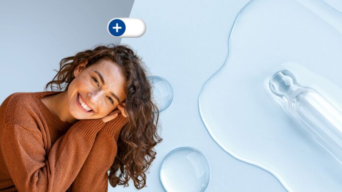 site-industries-cosmetiques Une femme souriante aux cheveux bouclés, vêtue d'un pull marron, appuie sa tête sur ses mains. À côté d'elle se trouvent des gouttes de liquide transparent et un compte-gouttes en verre sur une surface bleu clair. Une icône 