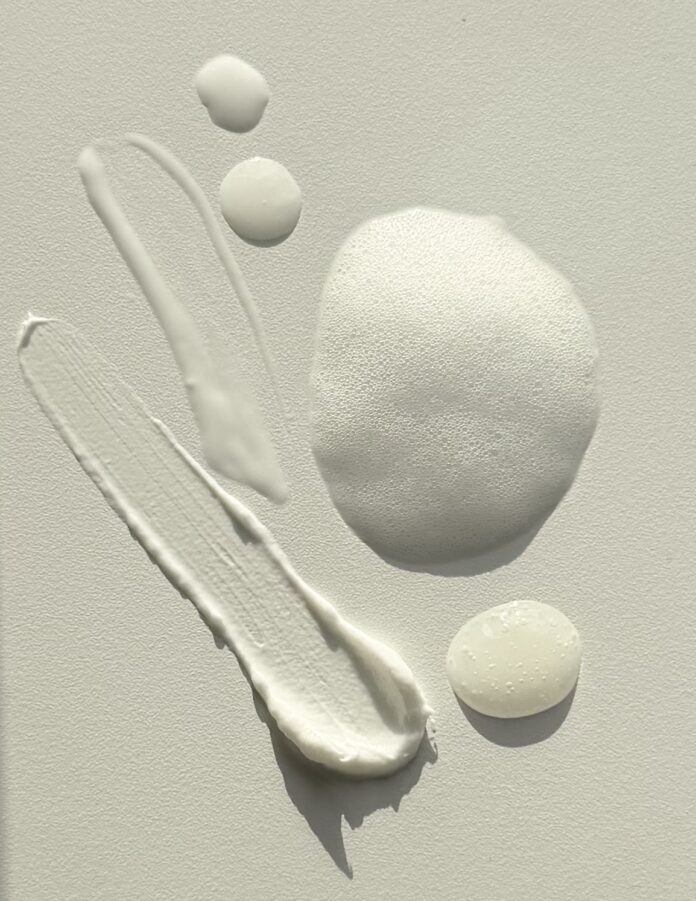 site-industries-cosmetiques Diverses formes de textures de produits de soin ou de cosmétiques sont disposées sur une surface lumineuse, y compris des substances crémeuses, mousseuses et gélatineuses de différentes formes et tailles.