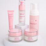 site-industries-cosmetiques Cinco produtos de cuidados da pele Arval Collageniques cor-de-rosa e brancos, incluindo dois frascos, um frasco doseador, um tubo e um doseador de espuma, estão dispostos num expositor redondo branco sobre um fundo branco liso.