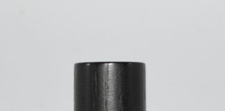 site-industries-cosmetiques 一个装满黄色液体的透明小玻璃瓶，瓶盖为黑色。瓶身上印有黑色的 "PARADES "字样，正面印有镜面字样。瓶底为白色。.