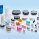 Lapac: tapones, cápsulas, sticks y recargas ecodiseñadas site-industries-cosmetiques Sobre un fondo azul claro, diversos recipientes de plástico, tapones y tapas de diferentes formas, tamaños y colores. Algunos son cilíndricos, otros ovalados o planos.