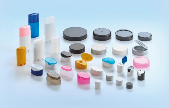 site-industries-cosmetiques 浅蓝色背景下是各种不同形状、大小和颜色的塑料容器、盖子和盖子。有些是圆柱形，有些则是椭圆形或扁平形。.