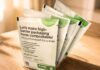site-industries-cosmetiques Apresentação de amostras de embalagens compostáveis da BASF num recipiente transparente sobre uma superfície de madeira, com texto a promover embalagens compostáveis domésticas de elevada barreira com benefícios ecológicos.