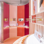 Yepoda inaugura «The Yepoda Haus Seoul», una tienda inmersiva en Seongsu site-industries-cosmetiques Un moderno espacio de exposición dedicado a los productos de belleza se compone de paredes curvas en tonos rosas y naranjas, estanterías con productos de cuidado personal, pantallas digitales sobre cada estante y carteles promocionales colgados en la pared. Una iluminación brillante y homogénea realza el conjunto.