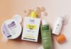 欧莱雅收购了印度Innovist公司的控股权 site-industries-cosmetiques Une composition « flat lay » de cinq produits de soin pour la peau et les cheveux, comprenant des crèmes, un gel douche, un shampoing et un flacon muni d’un bouchon orange, disposés sur une surface rose, avec des traces de produit et des éclaboussures de liquide tout autour.