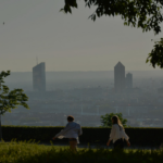 DKSH France Exceeds Its Carbon Reduction Target and Expands Its CSR Requirements site-industries-cosmetiques Two people are walking along a path lined with grass and trees, with the blurred silhouette of the city in the background and two skyscrapers standing out clearly. The scene appears to be taking place early in the morning or late in the afternoon.