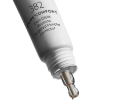 site-industries-cosmetiques Um tubo conta-gotas da Maria Galland Paris, com 19 mm, com a indicação «PURE COMFORT – Corretor específico anti-borbulhas», deposita uma pequena quantidade de creme na ponta do dedo indicador, sobre um fundo branco.