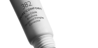 site-industries-cosmetiques Un tubo cuentagotas de Maria Galland Paris de 19 mm, con la inscripción «PURE COMFORT – Corrector específico anti-granos», aplica una pequeña cantidad de crema en la yema del dedo índice, sobre un fondo blanco.