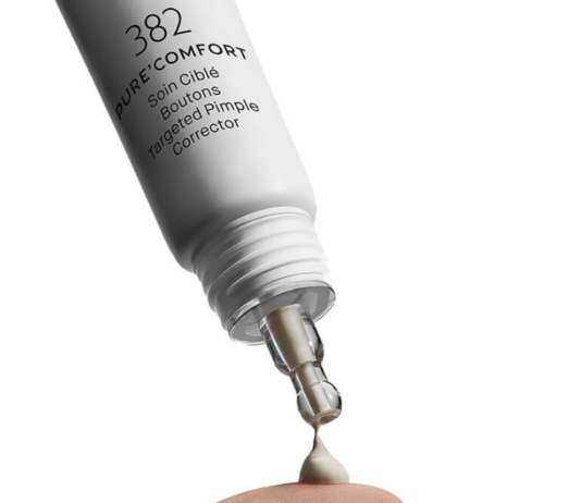 site-industries-cosmetiques Un tube compte-gouttes Maria Galland Paris de 19 mm, portant la mention « PURE COMFORT – Correcteur ciblé anti-boutons », dépose une petite quantité de crème sur le bout de l'index, sur un fond blanc.