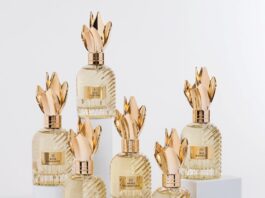 site-industries-cosmetiques Six flacons de parfum en verre, munis de bouchons dorés en forme de couronne, sont disposés sur des socles blancs. Chaque flacon présente une texture nervurée et une étiquette dorée sur laquelle sont imprimés des chiffres romains et des noms. Le fond est d'un blanc uni.