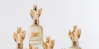 site-industries-cosmetiques Seis frascos de perfume de cristal, provistos de tapones dorados con forma de corona, están dispuestos sobre peanas blancas. Cada frasco presenta una textura acanalada y una etiqueta dorada en la que están impresos números romanos y nombres. El fondo es de un blanco liso.