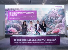 site-industries-cosmetiques Four people stand behind a podium with light decorations at the opening ceremony of the Evonik Asia Beauty Science & Innovation Center, in front of a floral decor and a sign displaying the name of the event in English and Chinese.