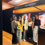MakeUp in Paris 2026: Mktg Industry Bets on a Hybrid Format site-industries-cosmetiques Four people are standing and posing for a photo in front of a black booth bearing the inscription «MKTG INDUSTRY,» at what appears to be a trade show or exhibition. The booth features makeup brands and promotional materials.