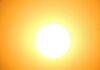 La FDA aprueba el filtro UV bemotrizinol de BASF site-industries-cosmetiques Un sol de un blanco resplandeciente ocupa el centro de la imagen, irradiando una luz amarilla y naranja que se va atenuando progresivamente hacia los bordes, creando un efecto cálido y luminoso sobre un fondo de cielo despejado.