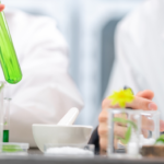 Solabia 完成对 Mibelle Biochemistry 的收购,并进一步扩充其生物技术资产组合 site-industries-cosmetiques 两名身穿实验服的人正在试管中操作一种绿色液体,周围摆放着玻璃器皿、植物、一个烧杯,以及放在实验台上的研钵和研杵。 这一场景让人联想到植物学或化学实验。.