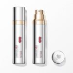 Lumson conçoit l’emballage d’Absolue Longevity MD de Lancôme site-industries-cosmetiques Deux flacons argentés de crème anti-âge, l'un muni d'un bouchon fermé et l'autre d'une pompe apparente, sont posés sur une surface blanche. Un bouchon argenté orné d'un motif de rose est placé à côté d'eux. Les étiquettes indiquent le nom du produit et celui de la marque.